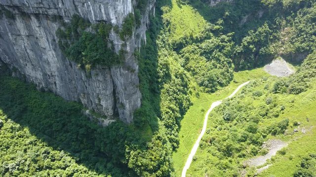 Earial view of the walking path at the bottom of the gorge valley surrounded by karst limestone rock formations in Wulong National Park, China