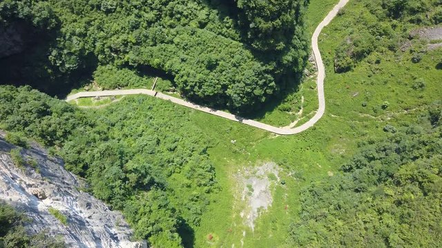 Earial view of the walking path at the bottom of the gorge valley surrounded by karst limestone rock formations in Wulong National Park, China