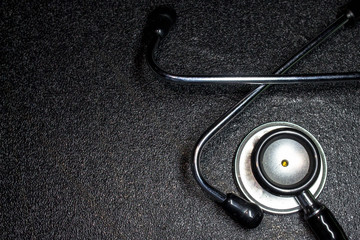 Stethoscope on a grainy black board.