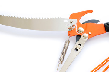 Close up pruning saw and pruning shears isolated on white background. Scissors, pulling with rope.
