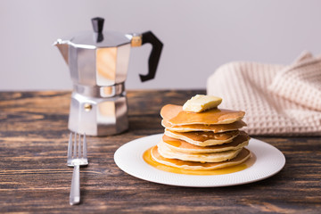 Golden pancakes with butter and warm maple syrup.