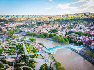 Peace bridge and Tbilisi old town from aerial perspective during the sunrise. Sightseeing and new tourism season in Sakartvelo. Georgia. 20204