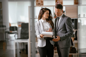 Colleagues in office. Businesswoman and businessman discussing work in office.	