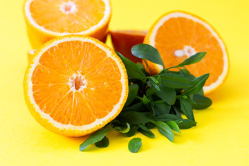 Fresh orange citrus fruit with leaves on yellow paper background. Juicy and sweet fruit. Concentration of vitamin C.