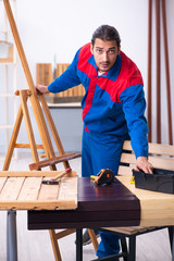 Young male contractor working in workshop