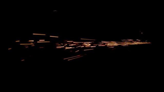 Fiery sparks fly from one point on a black background