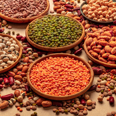 Legumes assortment on a brown background. Lentils, soybeans, chickpeas, red kidney beans, a vatiety of pulses, square shot