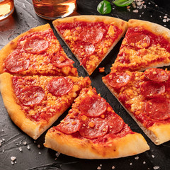Pepperoni pizza on a black background, square shot
