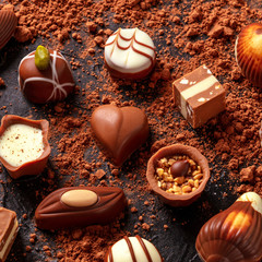 Belgian chocolate assortment, many different bonbons on a dark background, square image