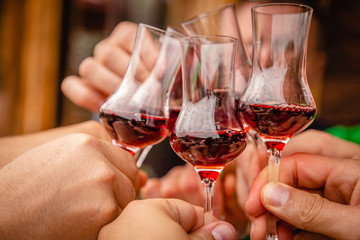 People clink glasses with red alcohol shots on a celebration