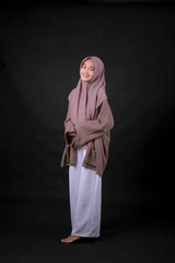 Young Asian Islam woman wearing headscarf is holding hands crossed with serious and confidence...