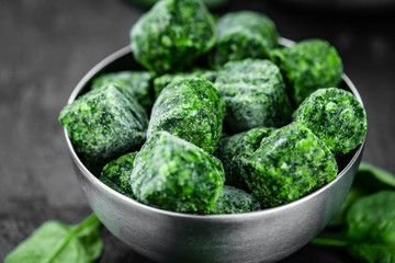 Frozen spinach cubes (close up; selective focus)