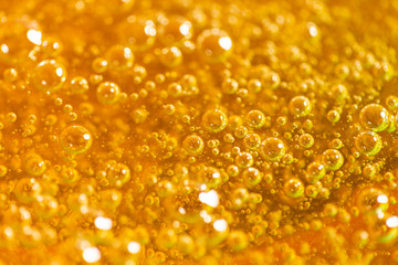 Detail of abstract orange bubble, can be used for background. Paste for sugaring close-up. Depilation and hair removal concept. Macro photo.