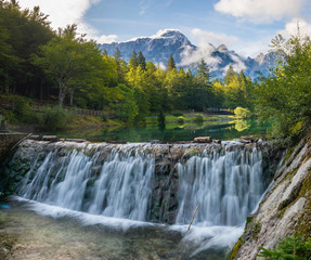 small waterfall on a stream flowing out of Lake Laghi di Fusine in the Julian Alps in Italy