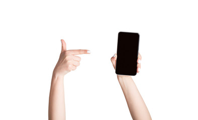 Girl pointing at mobile phone with empty screen, isolated on white. Mockup for your website or app design