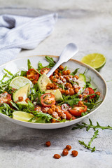 Roasted chickpea salad with avocado and tomatoes in white bowl. Healthy vegan food concept.