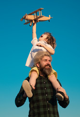 Father's day. Happy father and son on meadow in summer. Family holiday and togetherness.