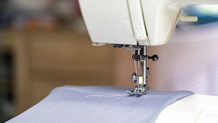Electric sewing machine with fabric and thread