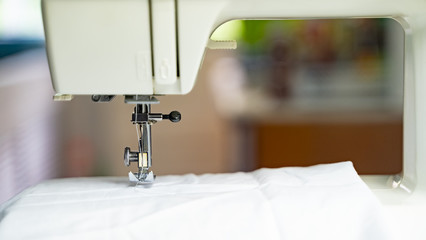 Electric sewing machine with fabric and thread