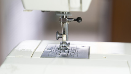 Electric sewing machine with fabric and thread
