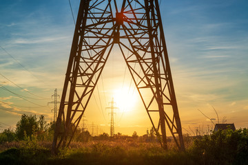 Power line support tower and sunset sun.