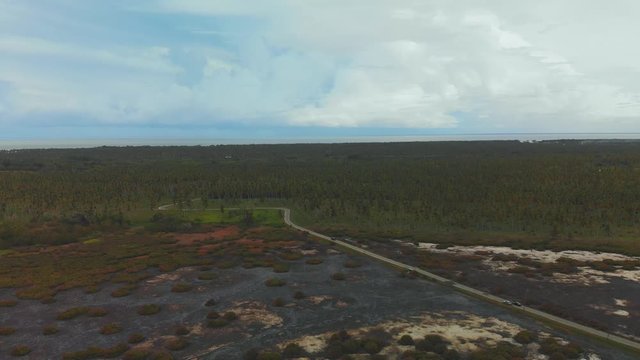 Aerial of coconut estates and wetlands through which an access road passes only to be greeted with a lagoon which has dried up leaving caked mud in its wake