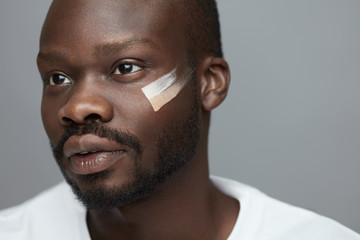 Male Makeup. Cosmetic Products On Facial Skin. African Model With Foundation Cream On Face. Beauty...