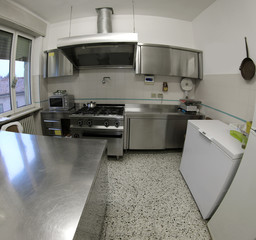 industrial kitchen with stainless steel stove and large extracto