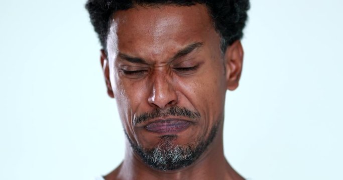 Person feeling disgust emotion portrait face close-up. African black man disliking