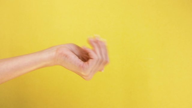 Come here or come on gesture. female hand on yellow background, beckoning and inviting gesture isolated