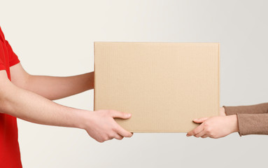 Woman hands accepting delivery of box from deliveryman