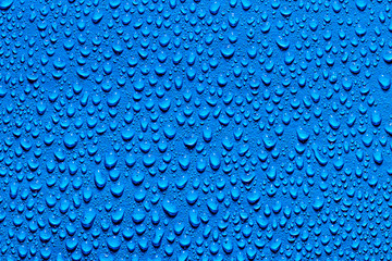Macro water drops texture on a blue background. Abstract pattern or blank for design.