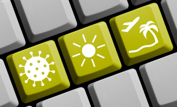 Urlaub in Zeiten vom Coronavirus - Symbole auf gelber Computer Tastatur