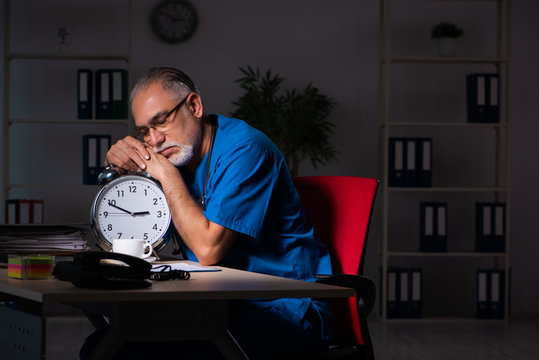 Aged male doctor in the hospital at night