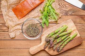 Asparagus with salmon and spices on table