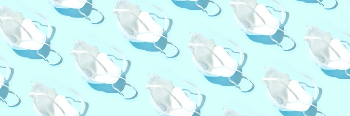 Many medical masks on the blue colored background to cover the mouth and nose for protection from virus and bacteria on a blue background.