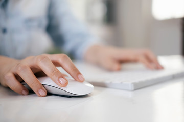 Closeup woman using computer mouse with computer keyboard