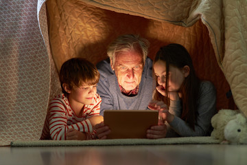 Kinder und Opa mit Tablet Computer oder E-Book