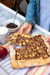 Apple crust tart pie with chocolate cream spread paste and cinnamon. Ingredients. Woman hands