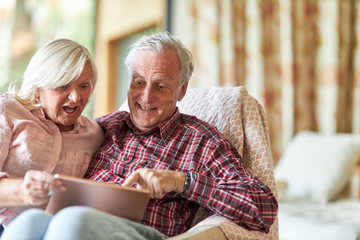 Fröhliches Senioren Paar staunt beim surfen im Web