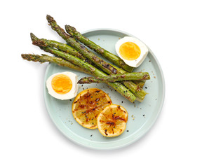 Cooked asparagus with egg and lemon on white background