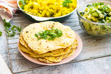 Indian flatbread - chapati with rucola green herbs. Vegan food.