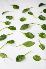 Small baby spinach leaves on white surface