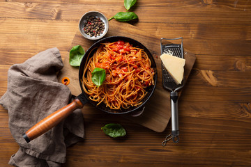 Whole wheat spaghetti in pan with tomato sauce