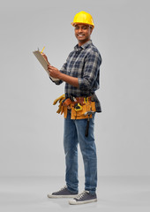 profession, construction and building - happy indian worker or builder in helmet with clipboard and pencil over grey background