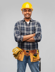 profession, construction and building - happy smiling indian worker or builder in helmet with crossed arms over grey background