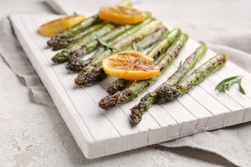 Cooked asparagus with lemon on board