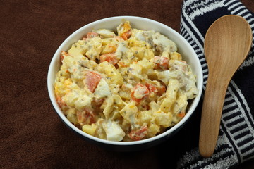 Traditional potato salad with boiled chicken egg and fresh carrot seasoning with mayonnaise cream on the bowl. Famous healthy comfortable breakfast in the morning. Low fat and high nutrition food.