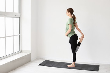 Obraz premium Young pregnant woman practicing yoga in gym