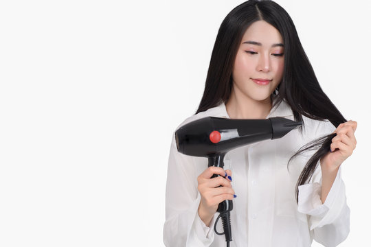 Portrait of asian woman uses hair dryer on white background free from copy space. This image for business woman make up before work.